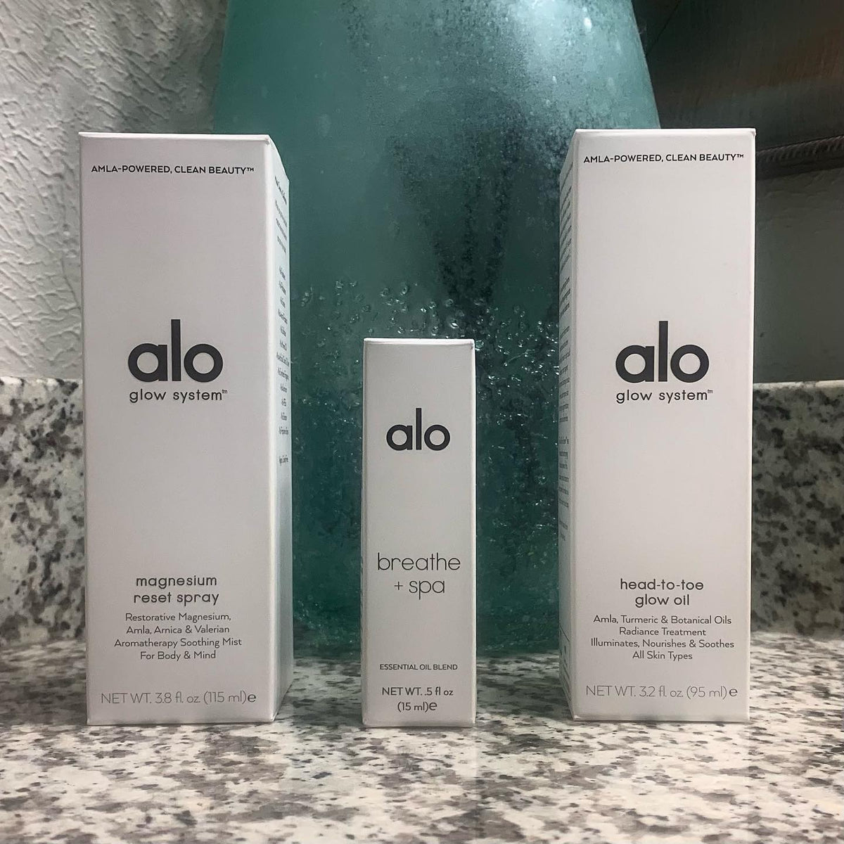Magnesium Reset spray, Head-To-Toe-Glow Oil, and Breath + Spa Essential Oil Blend boxes on marble